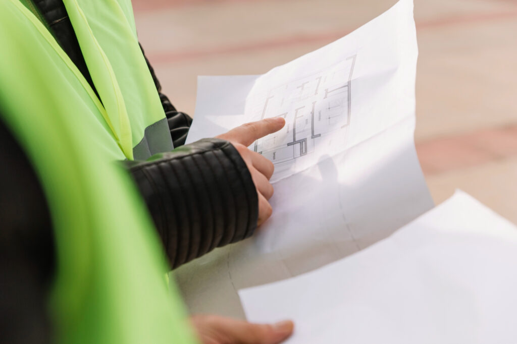 Operario sosteniendo planos para el certificado de fin de obra